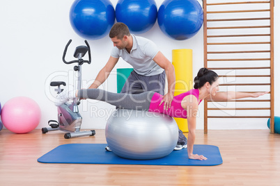 Trainer with woman on exercise ball