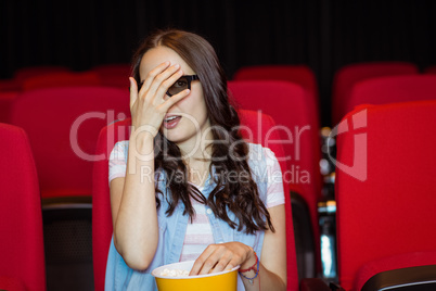 Young woman watching a scary 3d film