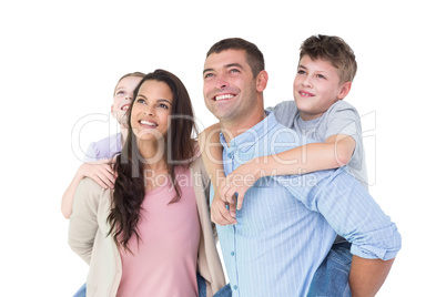 Happy parents giving piggyback ride to children while looking up