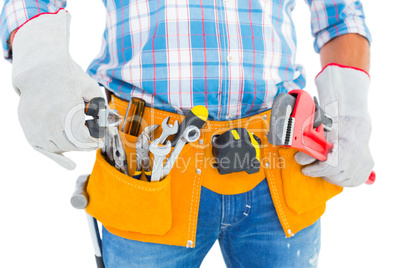 Midsection of handyman holding hand tools