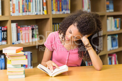 Student reading book in library