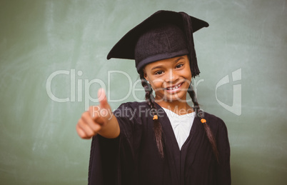 Girl in graduation robe gesturing thumbs up
