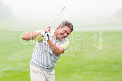 Golfer swinging his club on the course