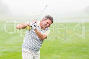 Golfer swinging his club on the course