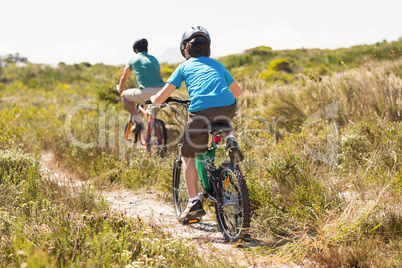 Father and son biking through mountains