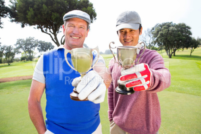 Golfing friends showing their cups