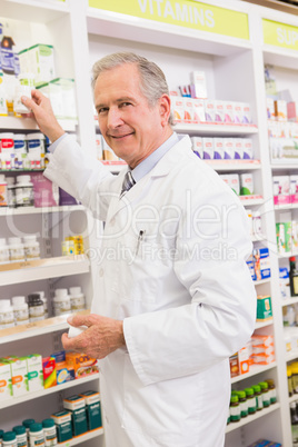 Pharmacist taking medicine from shelf