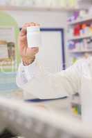 Hand of pharmacist showing medicine jar
