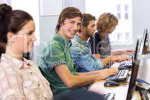 Student smiling at camera in computer class