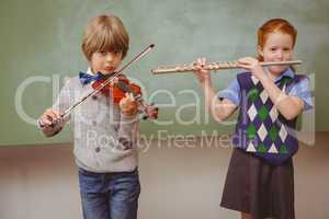 Students playing flute and violin in classroom
