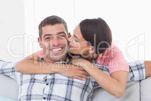 Happy man being kissed by woman