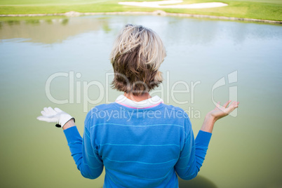 Confused female golfer looking at lake