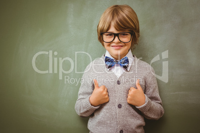 Little boy gesturing thumbs up against blackboard