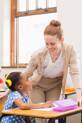Teacher and pupil working at desk together