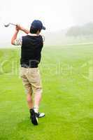 Golfer teeing off