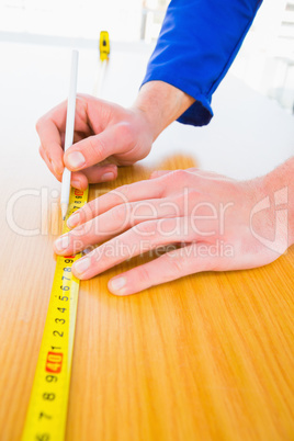 Handyman measuring wood board