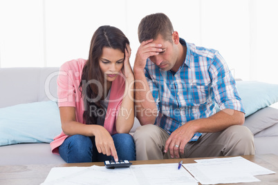 Tensed couple calculating home finances