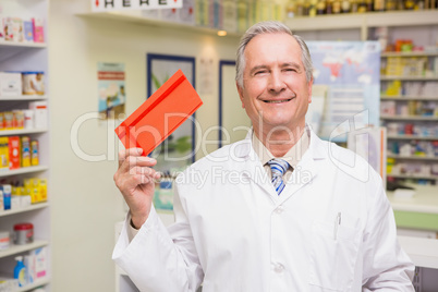 Smiling senior pharmacist showing envelope