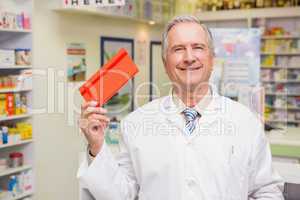 Smiling senior pharmacist showing envelope