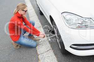 Young woman replacing tire