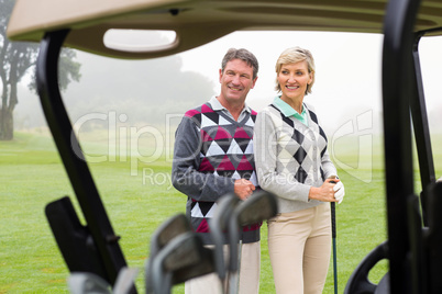 Happy golfing couple smiling