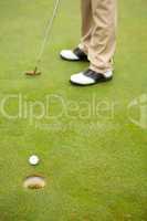 Golfer on the putting green at the hole