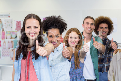 Confident fashion designers gesturing thumbs up