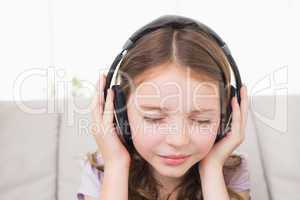 Girl with eyes closed listening music through headphones