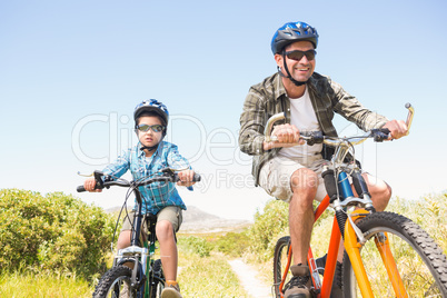 Father and son biking through mountains