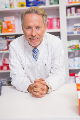 Smiling pharmacist posing on desk