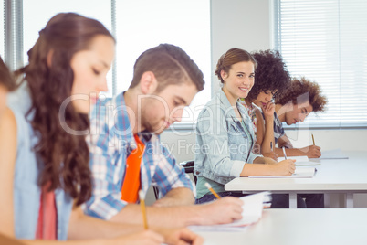 Fashion student smiling at camera in class