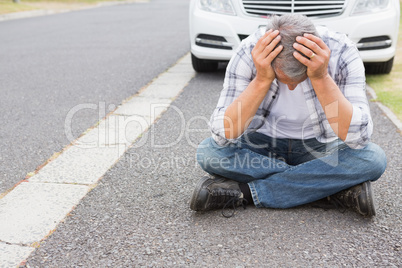 Stressed man sitting on the ground