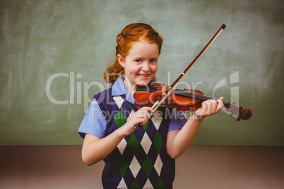 Cute little girl playing violin in classroom