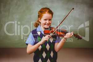 Cute little girl playing violin in classroom