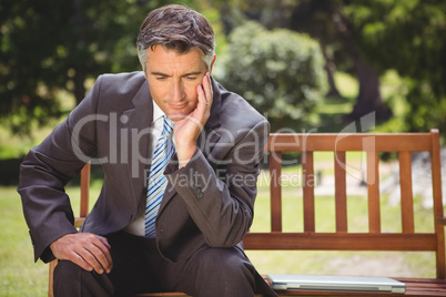 Businessman thinking in the park