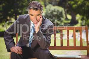 Businessman thinking in the park