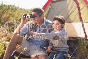 Father and son beside their tent in the countryside