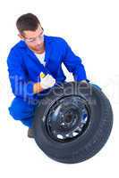 Mechanic working on tire over white background