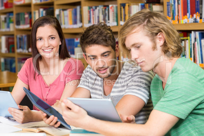 College students using digital tablets in library