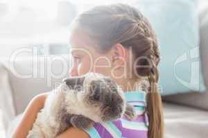 Girl holding rabbit at home