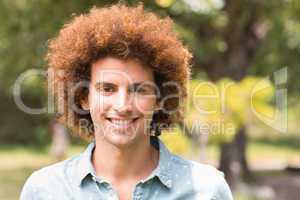 Young man smiling at camera in park