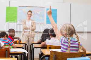 Pupil raising hand during geography lesson in classroom