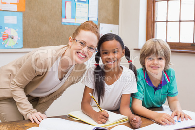 Teacher and pupils working at desk together