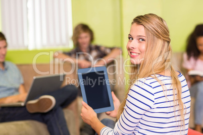 Casual young woman using digital tablet in office