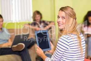 Casual young woman using digital tablet in office