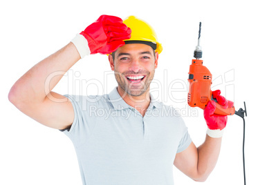 Smiling manual worker holding drill machine