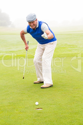 Happy golfer cheering on putting green