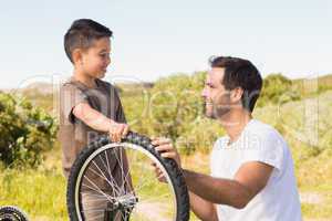 Father and son repairing bike together