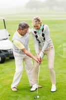 Golfing couple putting ball together