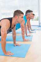 Group of men working on exercise mat